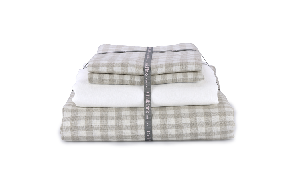 A Gingham Natural Linen Duvet Cover that is Folded with Ribbon