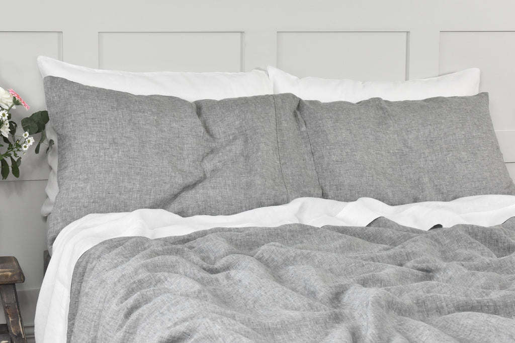 A Grey Linen Pillowcase on a Bed with White Linen Sheets and White Linen Pillowcases