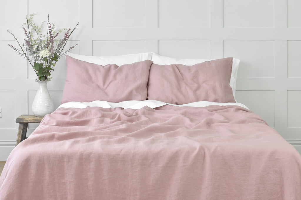 Vintage Rose Pink Linen Bedding on a Bed in a Bedroom with a Grey Paneled Wall 