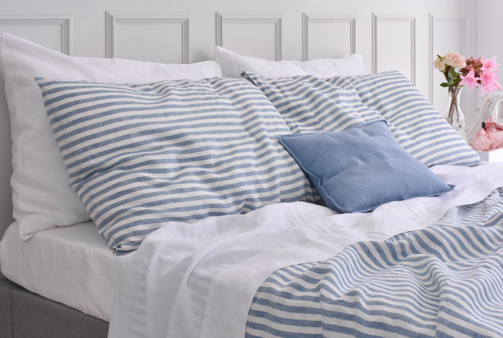French Blue Ticking Linen Pillowcase on a bed with white linen sheets