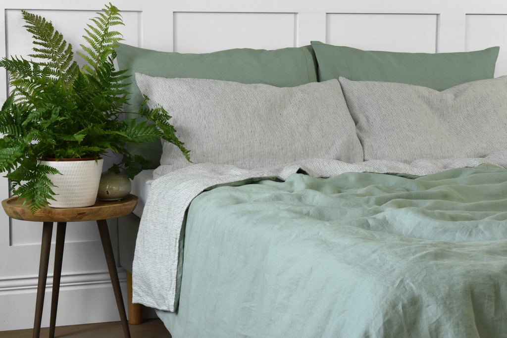 Stripey Linen Pillowcases on a Bed with a Sage Green Linen Double Sided Duvet Cover