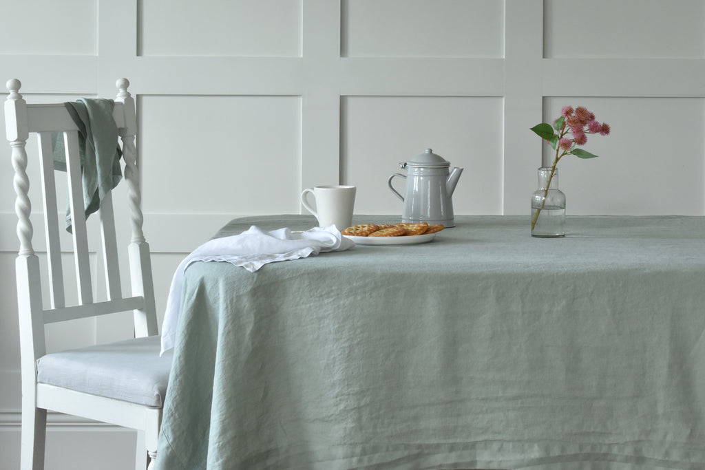 A Sage Green Linen Tablecloth on a Table with White Linen Napkins