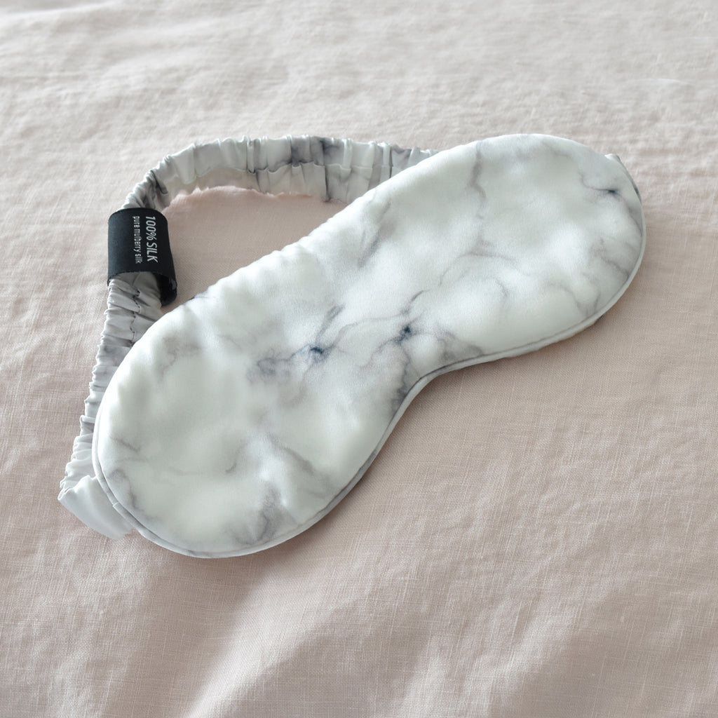 White Marble Silk Eye Mask on a Pink Linen Bed Sheet