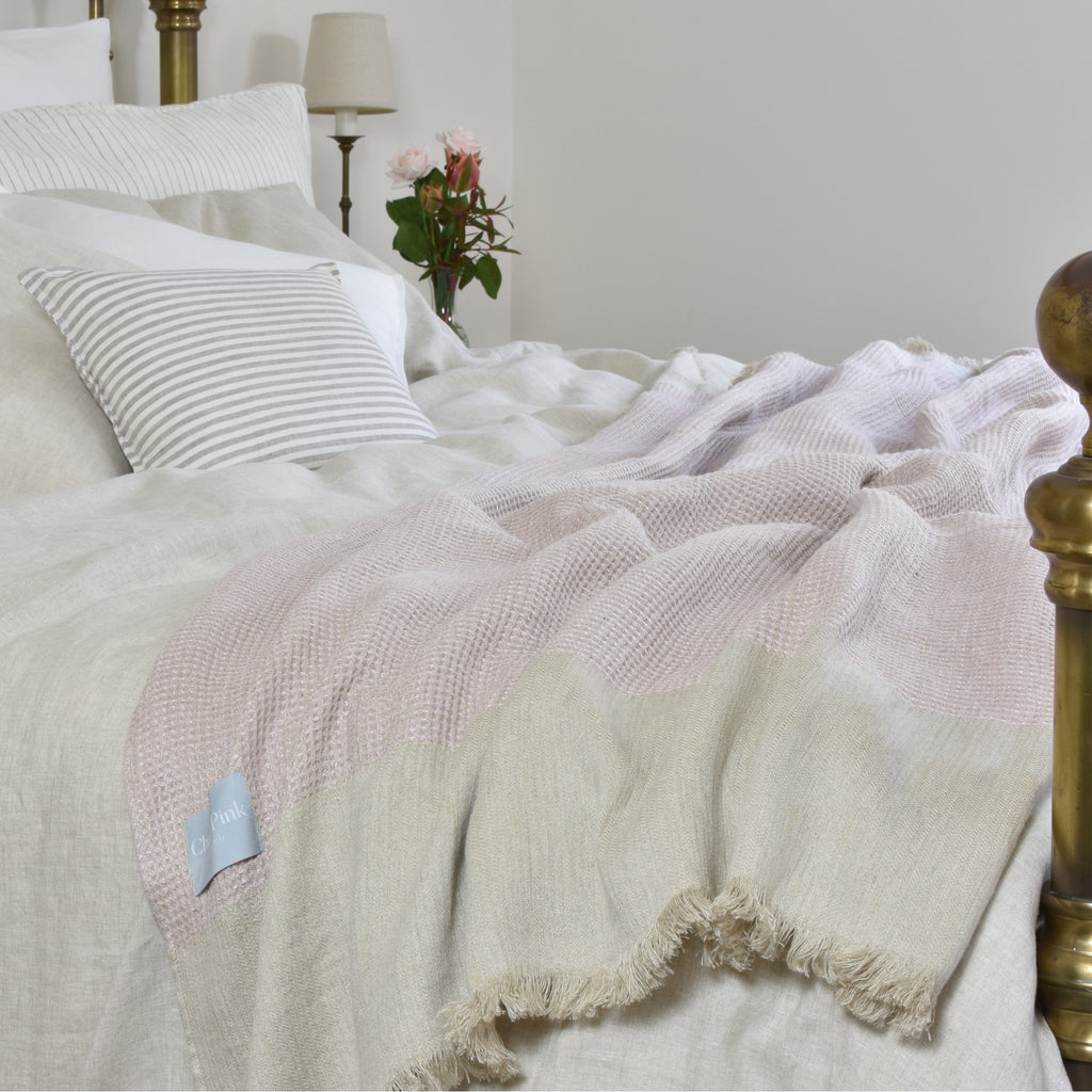 A Natural Linen Duvet Set on a Bed with a Baby Pink Blanket