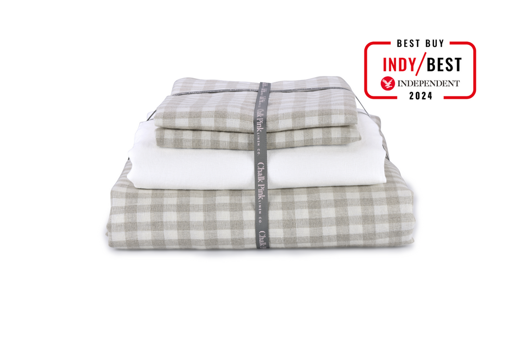 A Gingham Natural Linen Duvet Cover that is Folded with Ribbon