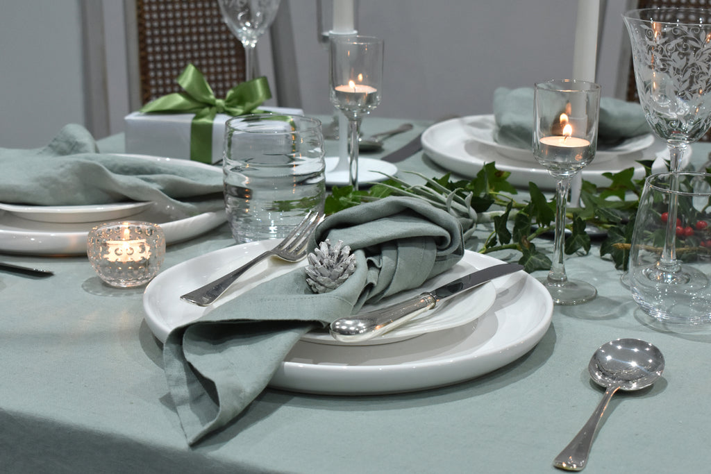 A Sage Green Linen Napkin on a Christmas Table with a Green Linen Tablelcoth