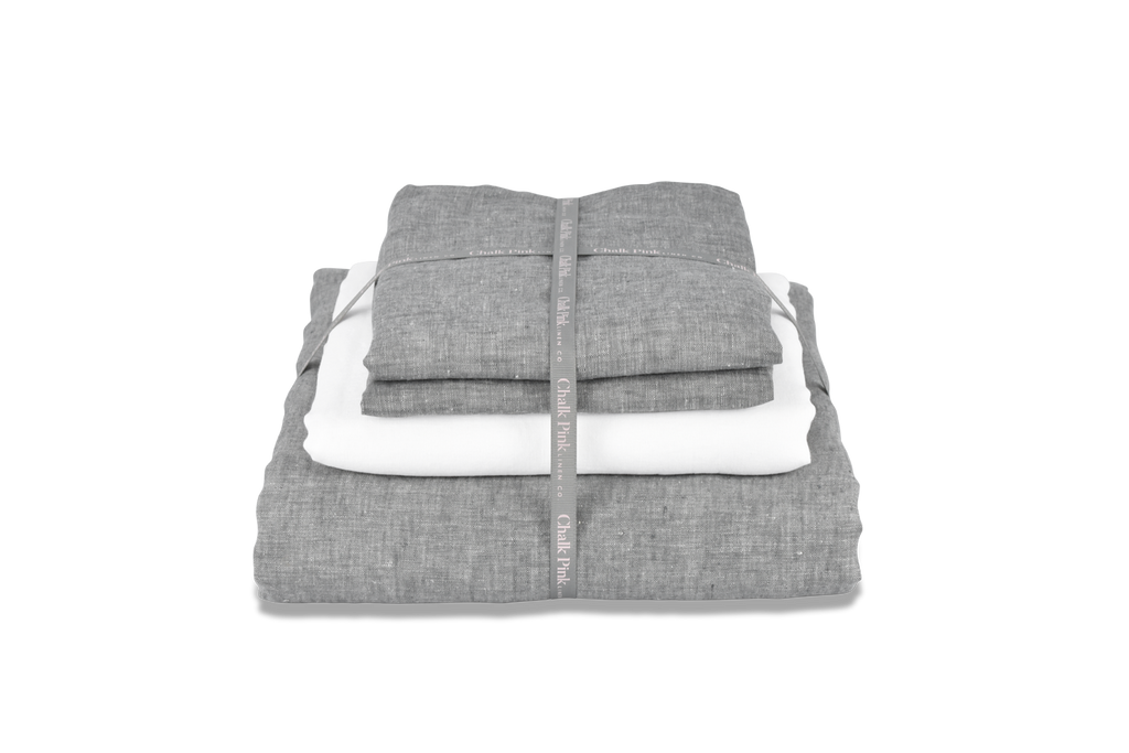 A Folded Linen Duvet Cover with a White Sheet and Ribbon