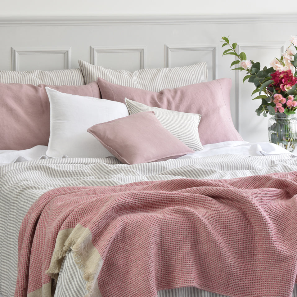 Light Pink Pure Linen Throw on a Linen Natural Ticking duvet cover with White Linen Sheets on a King Sized Bed