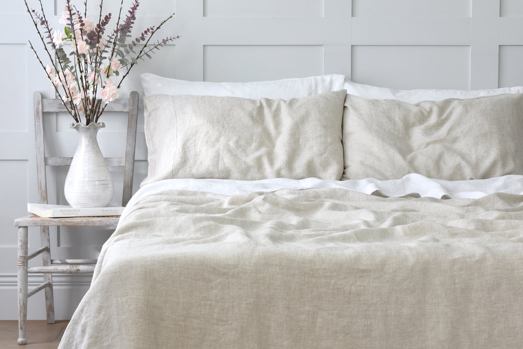 Natural Flax Linen Bedding on a Bed in a Bedroom with a Grey Panelled Wall
