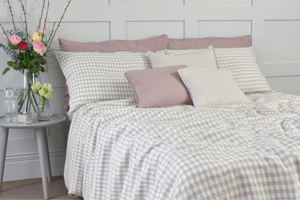 A Double Bed With Natural Gingham Bedding and Pink Linen Pillowcases