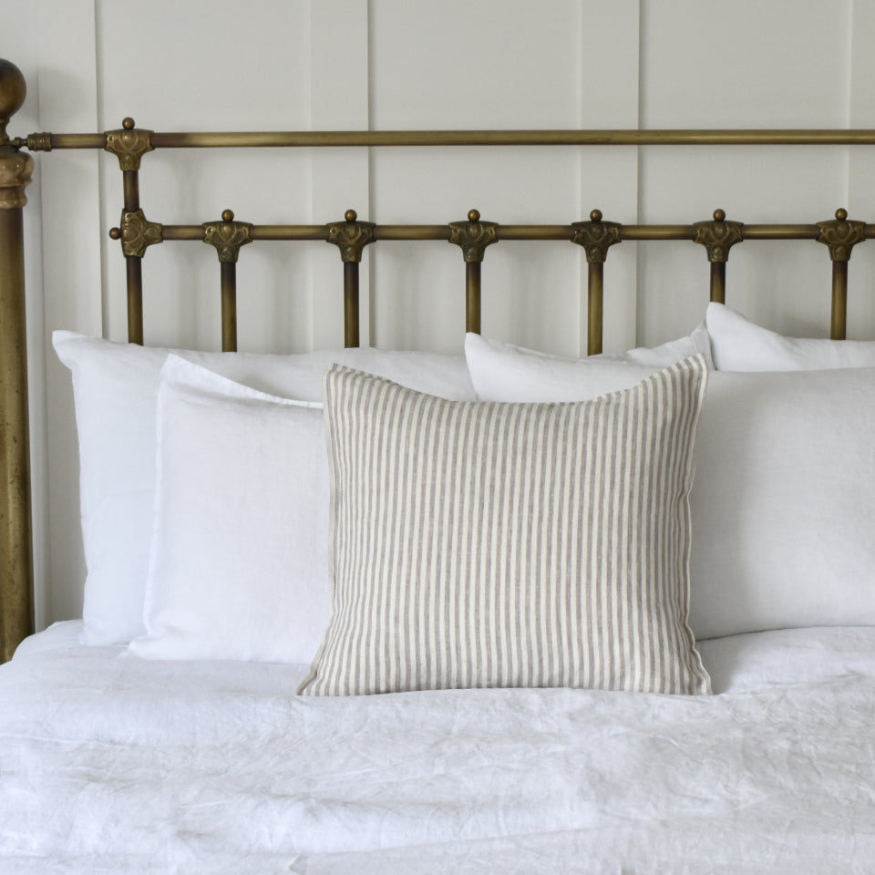 Grey Ticking Stripe Linen Cushion on a White Linen Bed