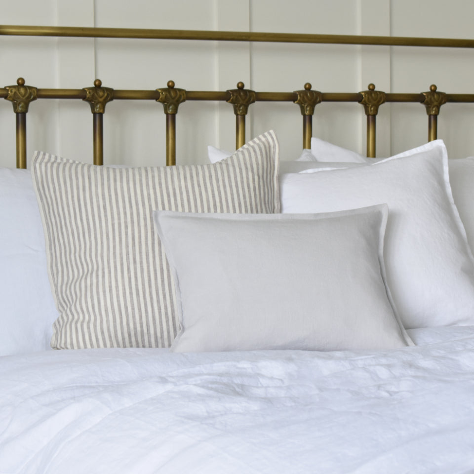 Light Grey Linen Cushion Cover on a Bed with a White Linen Duvet Cover