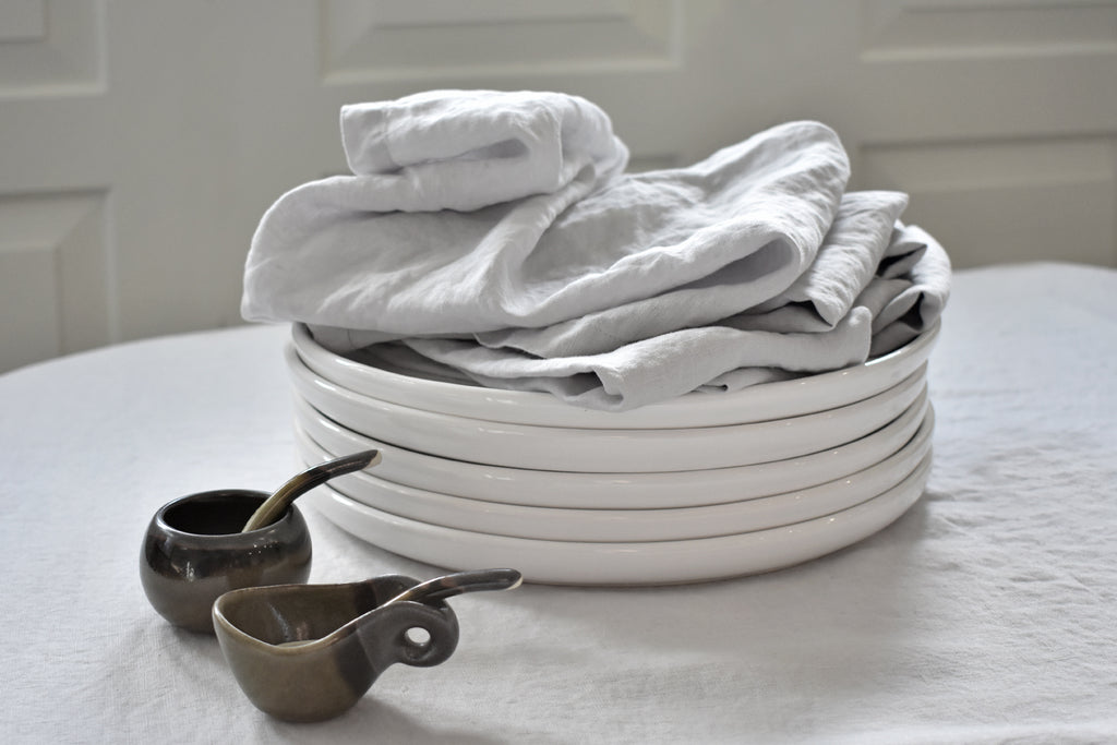 Light Grey Linen Napkins on a Stack of White Plates