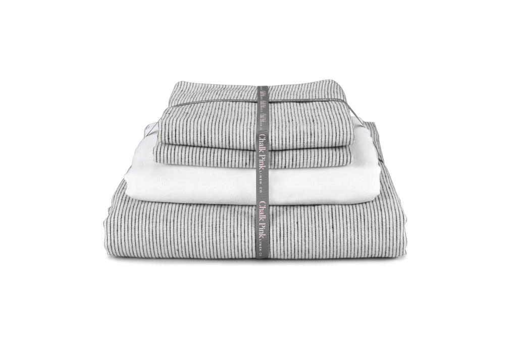 A Folded Pinstripe Linen Bedding Set with Ribbon on for a Gift