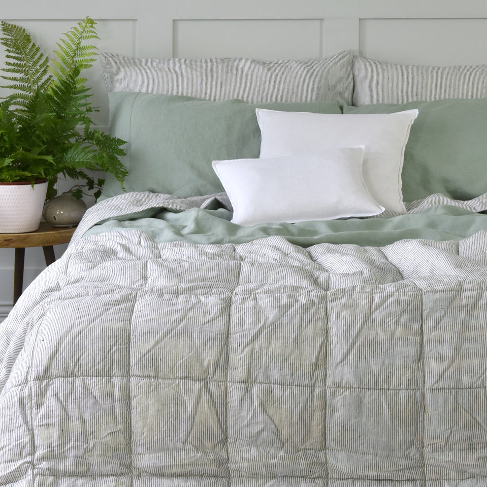 A Linen Quilted Bedspread on a Bed with a Green Linen Duvet Cover and Stripe Pillowcases