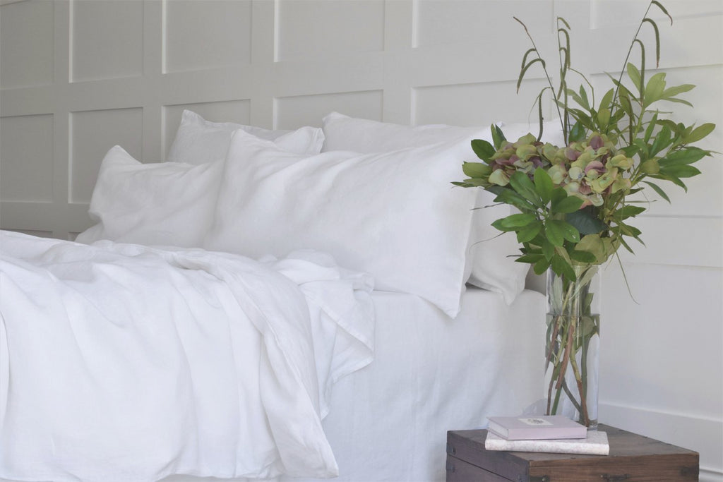 White Pure Natural Linen Bedding on a King Bed with Flowers on a Table