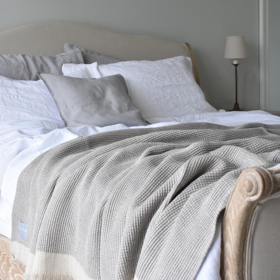 Grey Linen Throw on a Bed with White Linen Duvet Cover and Cushions