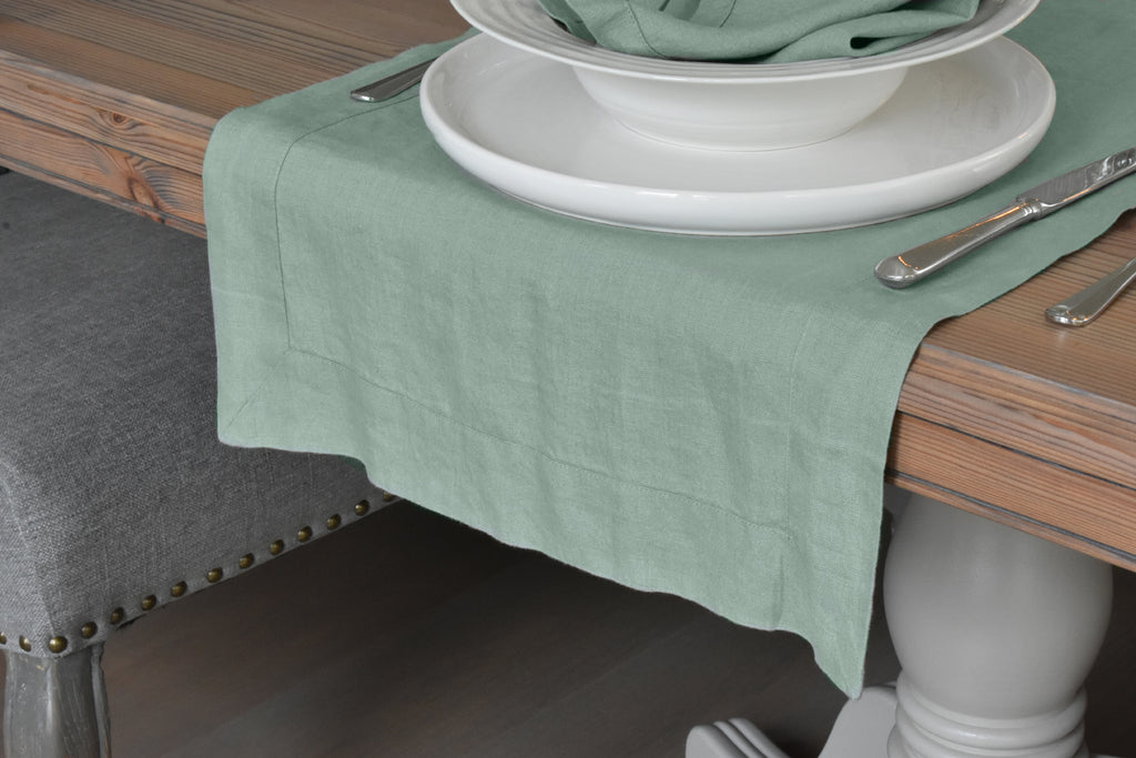 A Sage Green Linen Table Runner on the End of an oak Table